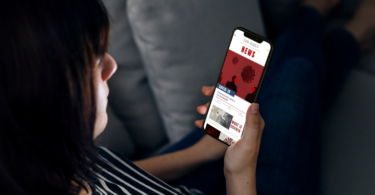 nepnieuws, filterbubbel. Vrouw leest nieuws op smartphone