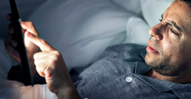 Afbeelding bij artikel hoe grijp je in bij online kwetsend gedrag? Man met smartphone