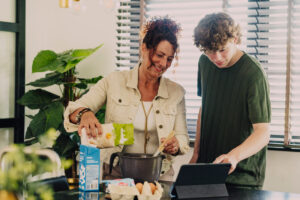 Moeder en zoon bakken samen terwijl ze naar een tablet kijken