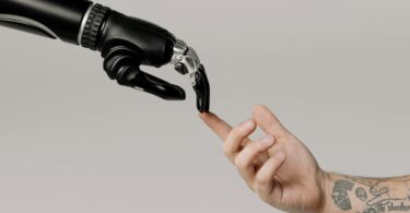Een robothand reikt naar een mensenhand.